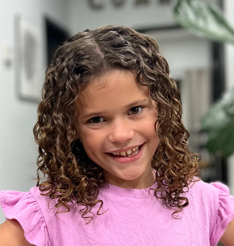 Young girl with defined curls after a custom kid’s curly cut in Lake Forest, CA.