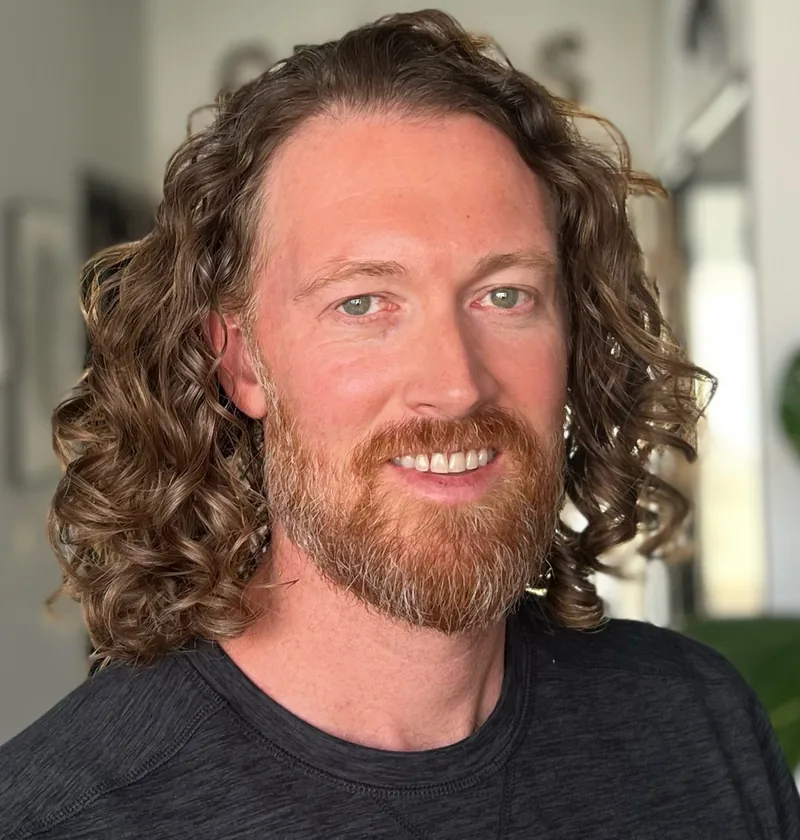 A man with long, defined curls after a men’s curly cut in Lake Forest, CA